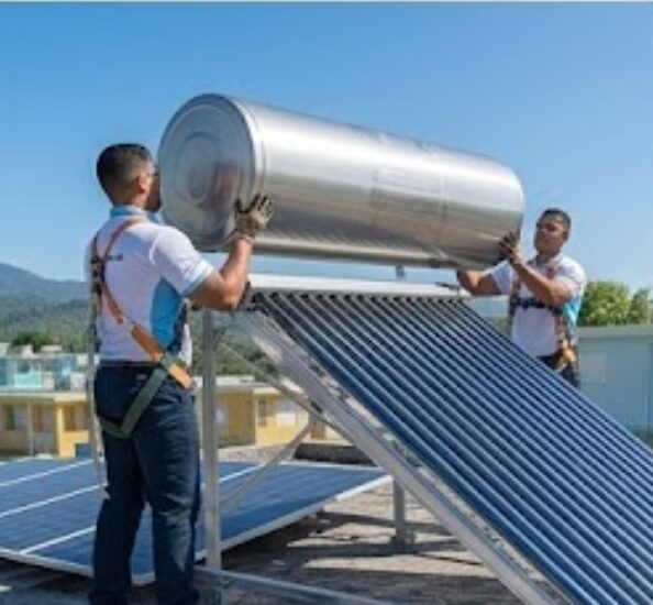 Técnicos instalando un calentador solar en un techo en Puerto Rico